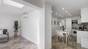 A modern apartment with a dining area, kitchen, and living space.