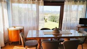 Comedor con mesa, sillas y vistas al exterior.