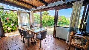 Un comedor con una mesa, sillas y un mueble para televisión.