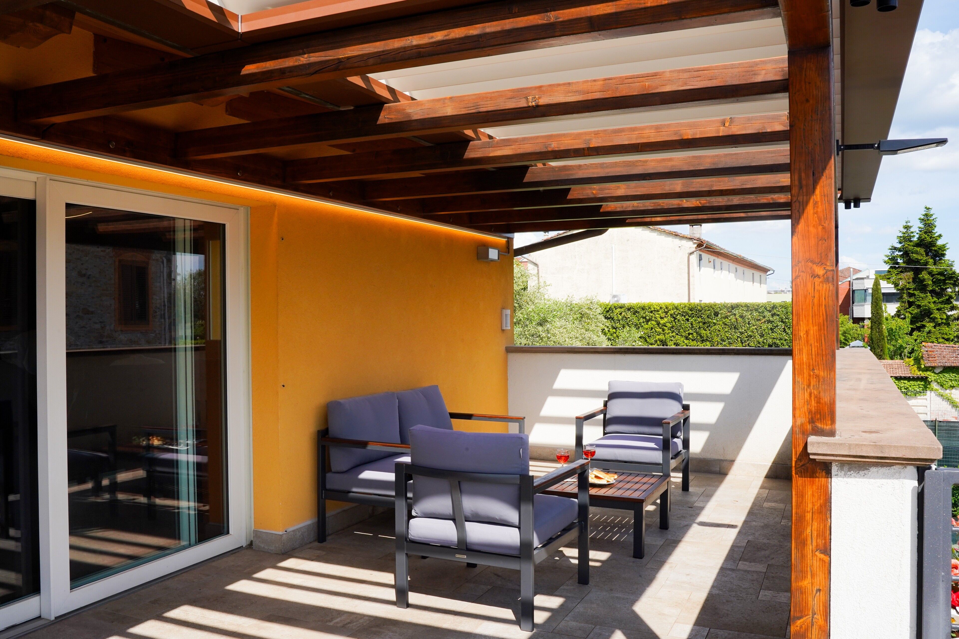 Une terrasse extérieure dotée d’une pergola en bois, d’un canapé et d’une table.