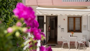 A building with a white facade, a balcony, and a door leading to an interior space. - Holiday Home 'Acolhedora' with Private Garden, Wi-Fi and Air Conditioning (Lagos)