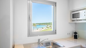 A kitchen with a window, a sink, and a microwave. - Apartment 'Sa Maniga' with Sea View, Wi-Fi and Air Conditioning (Sant Llorenç des Cardassar)