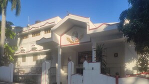 A building with a white facade, red trim, and a gated entrance. - Hotel St Thomas International Centre (Chennai)