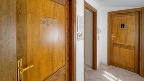 A hallway with wooden doors, one labeled 'Bathroom' and another with a number sign. - 49 Sea Rooms - Blue Room (Stintino)