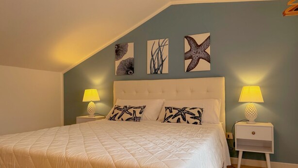 A bedroom with a large bed, two bedside tables with lamps, and three wall-mounted artworks. - 49 Sea Rooms - Blue Room (Stintino)