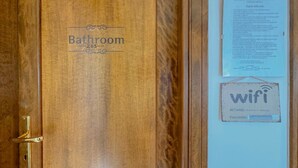A wooden door labeled 'Bathroom 203' with a 'wifi' sign and a notice on the wall. - 49 Sea Rooms - Blue Room (Stintino)