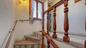 A staircase with wooden balusters, a handrail, and patterned steps.