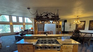 A spacious kitchen with a large island, wooden cabinets, and a gas stove. - PICKLEBALL Paradise! HotTub/Huge GameRoom/Mtn views/Fido Friendly/best location! (Grand Lake)