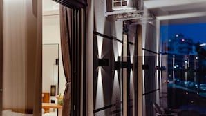 A modern interior with a glass door leading to a balcony with outdoor seating. - Gloal Suites Residence (Sarande)