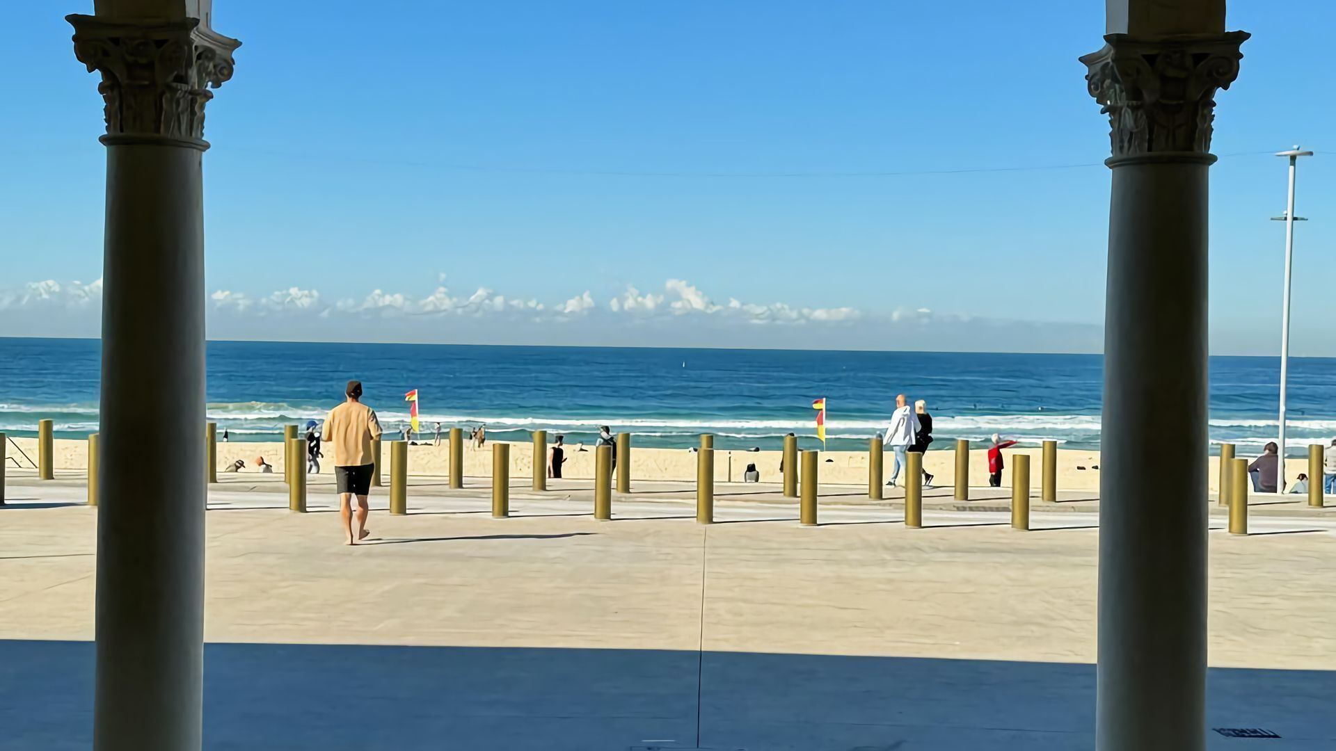 Un paseo marítimo con vista despejada al mar, con varios boquetones y columnas.