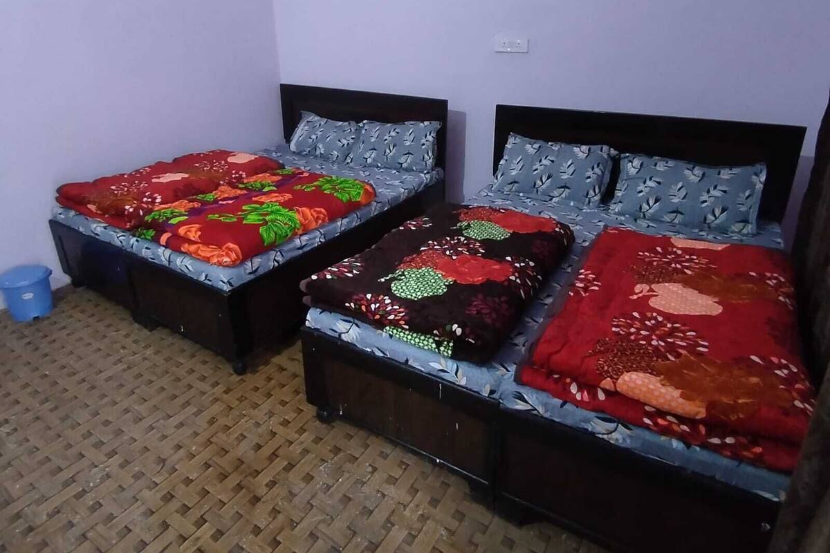 A room with two beds, each with a distinct floral bedspread.