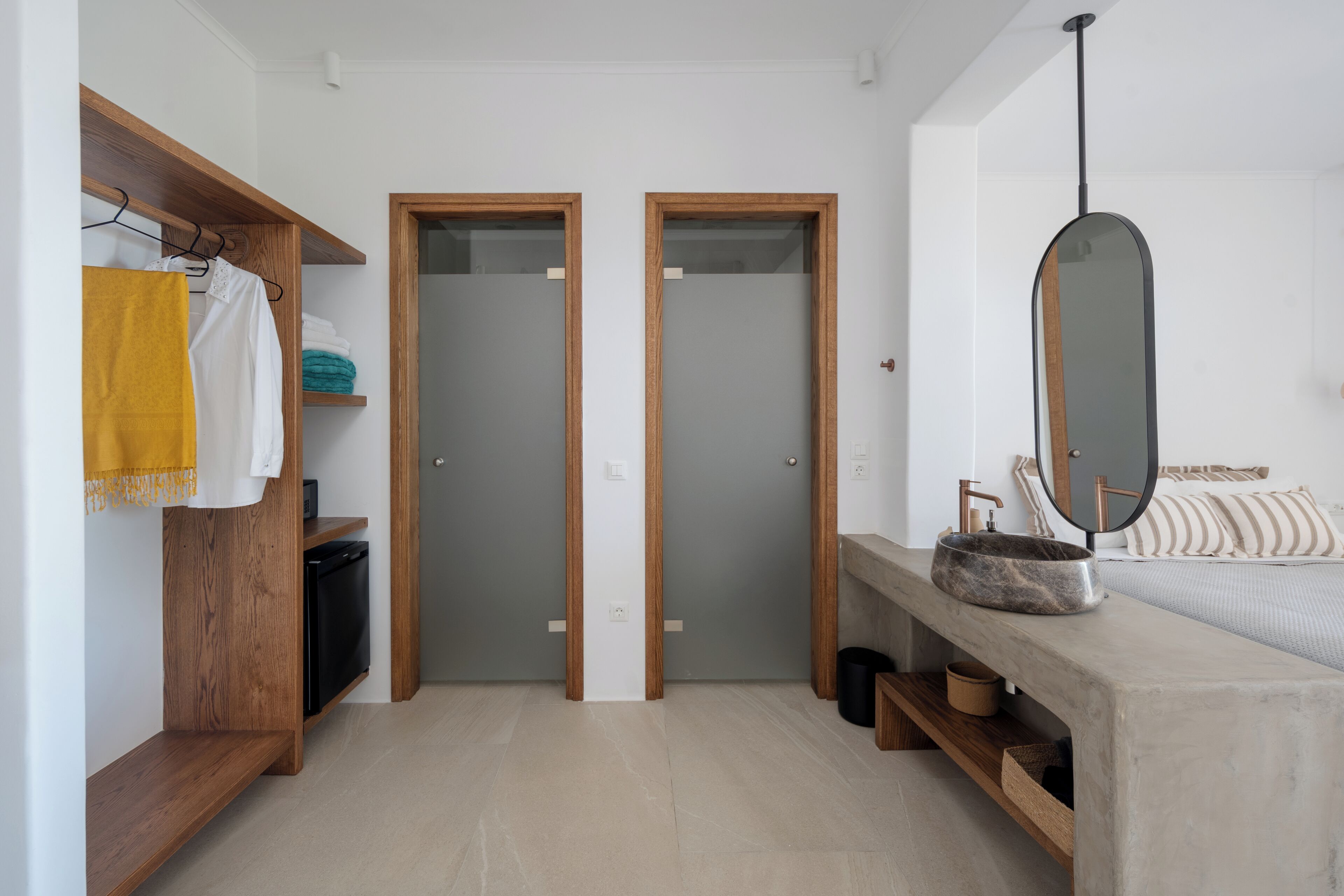 A modern bathroom with a wooden vanity, a large mirror, and a built-in sink.