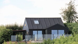 A modern house with a sloped roof, large windows, and a small balcony. - "Valia" - 20m from the sea by Interhome (Sønder Stenderup)