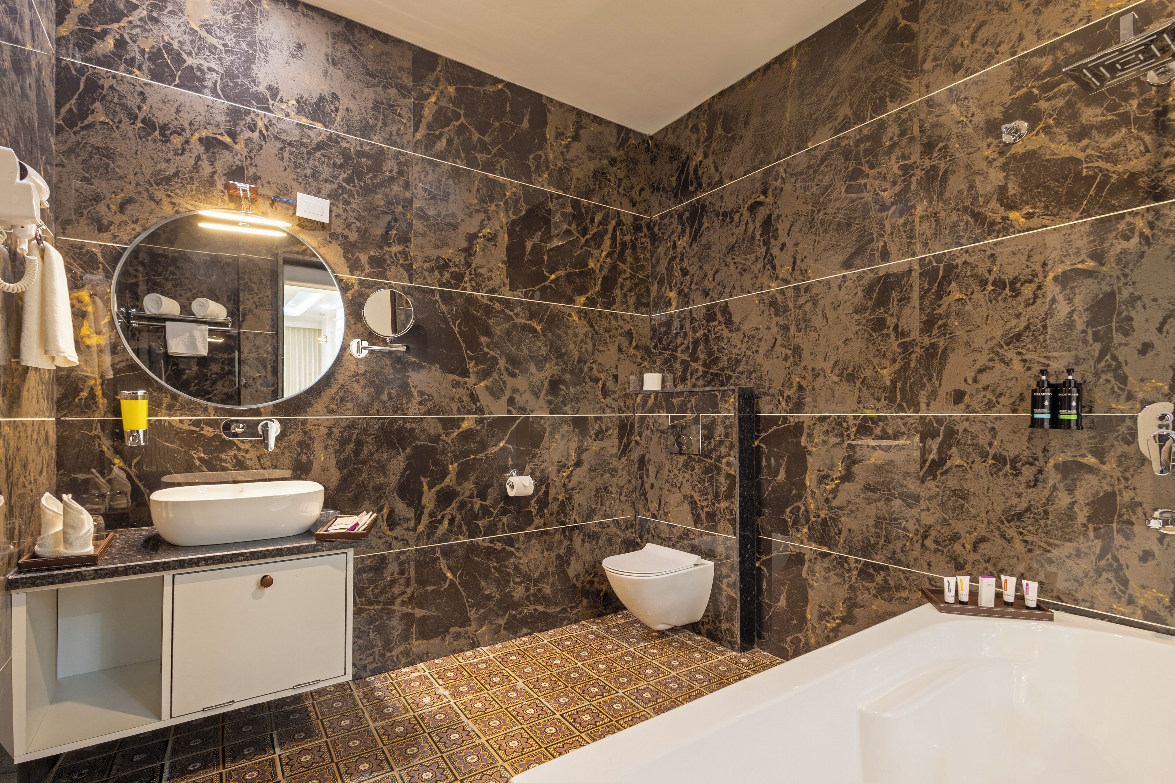 A modern bathroom with a large bathtub, a round sink, and a toilet.