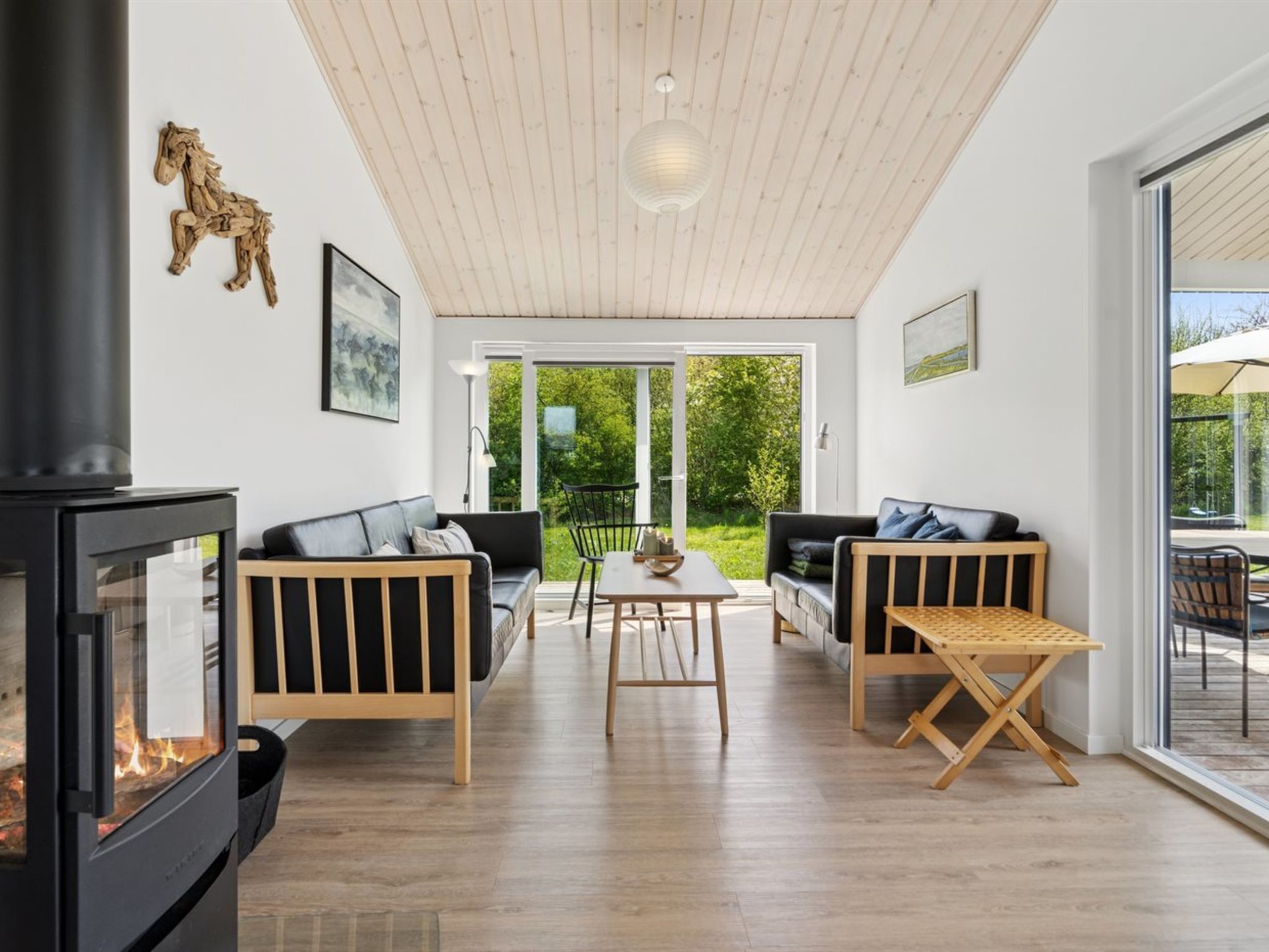 Un salon moderne avec une cheminée, deux canapés, une table basse et une table à manger.