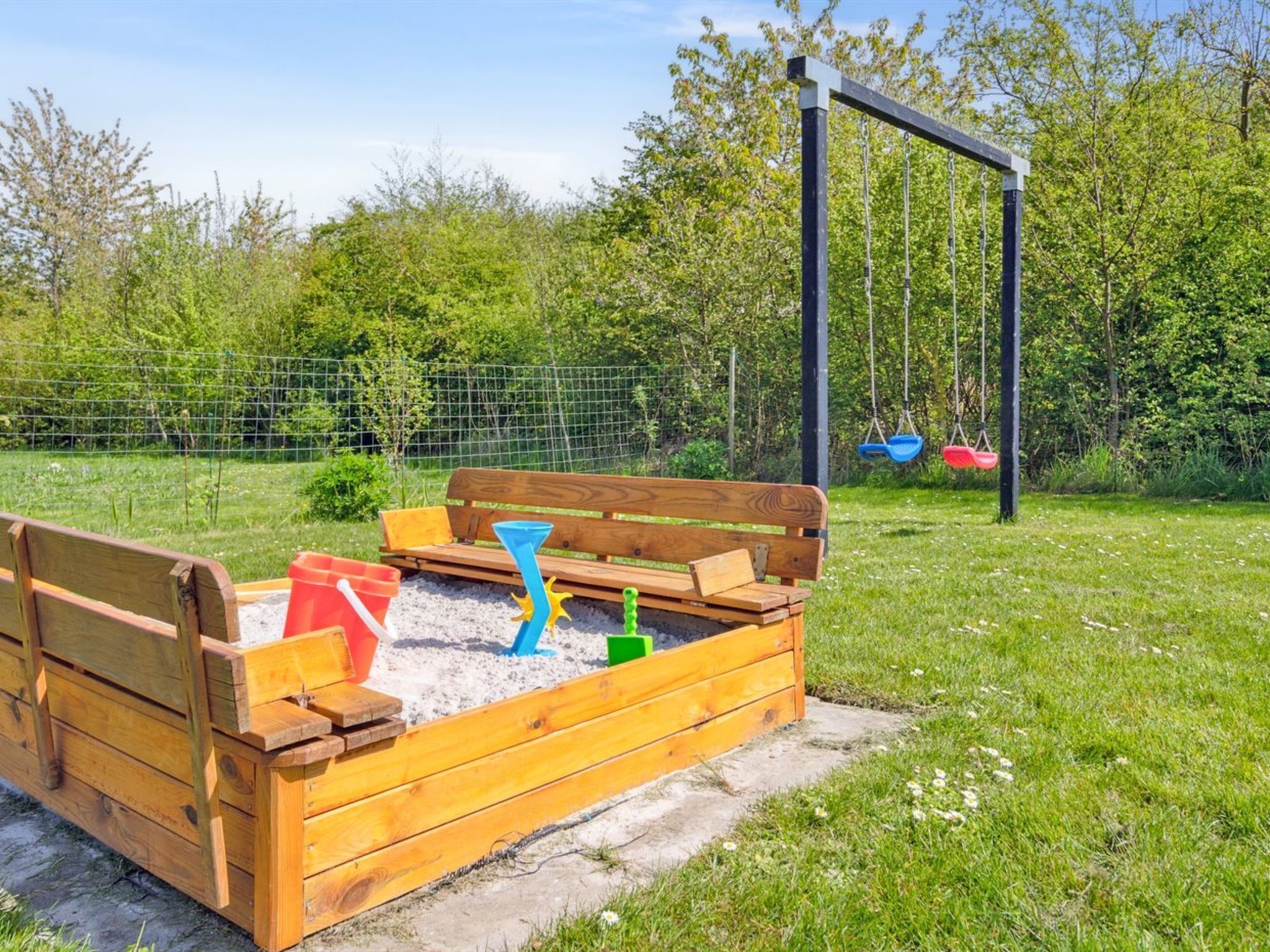 Une structure de jeu en bois comprenant un banc et une balançoire.