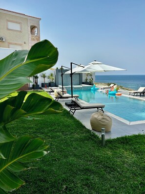 Relax by the pool surrounded by lush greenery and take in the breathtaking ocean views.