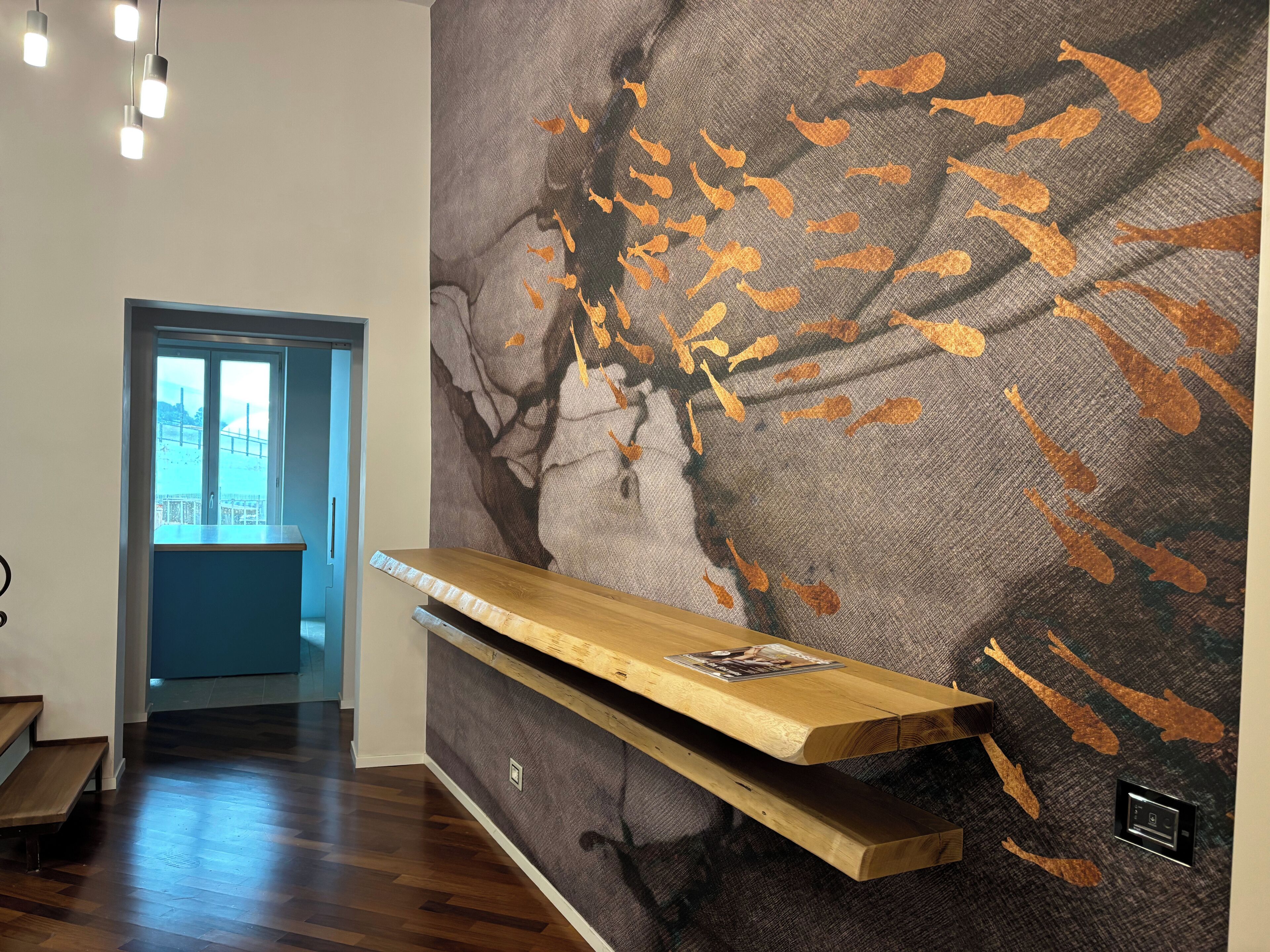 A modern interior with a wooden bench, a wall-mounted shelf, and a large abstract mural.