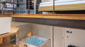 A modern hotel room with a glass-enclosed balcony, a spa tub, and a wooden floor. - Noto Boutique Hotel (Noto)