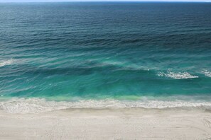 Ein Strand mit klarem türkisfarbenem Wasser und einem sandigen Ufer.