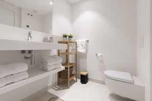 Een haardroger, handdoeken, zeep, toiletpapier