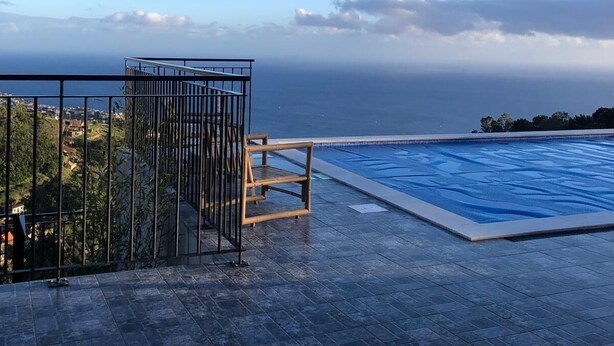 A swimming pool with a view of the sea, a wooden deck, and a metal railing. - Imperio vert adventure with a view (Tabua)