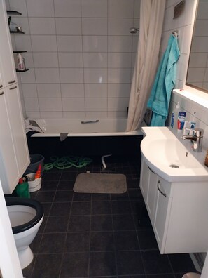 A bathroom with a bathtub, toilet, and sink.