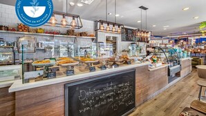 A cafe with a variety of food items displayed in glass cases and on shelves, a chalkboard with a quote, and a logo for 'United Bowl Nation'. - The Grace Bay' Private Rooftop Penthouse Water Views Retreat Pool Sauna and Gym (Marina del Rey)
