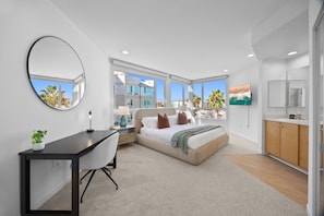 A modern bedroom with a bed, desk, and large windows. - The Grace Bay' Private Rooftop Penthouse Water Views Retreat Pool Sauna and Gym (Marina del Rey)
