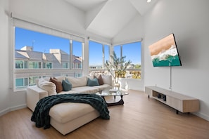 A modern living room with a sofa, coffee table, and a TV on a stand. - The Grace Bay' Private Rooftop Penthouse Water Views Retreat Pool Sauna and Gym (Marina del Rey)