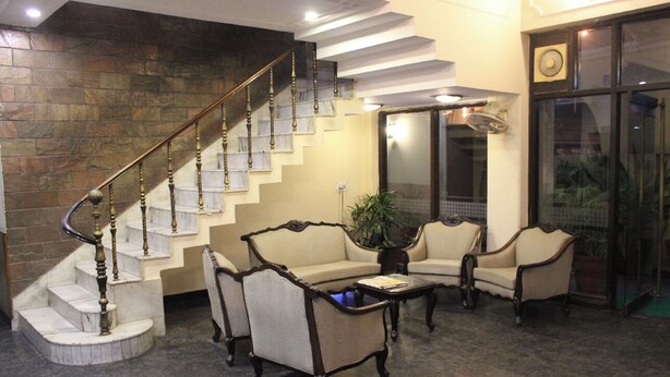 Eine Lobby mit einer Marmortreppe, einer Sofagruppe und einem Couchtisch.