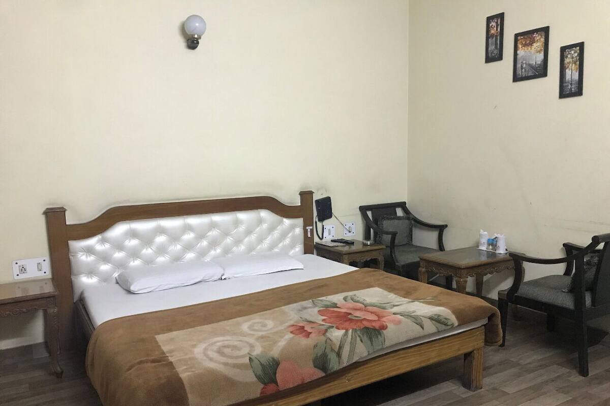 A bedroom with a bed, bedside tables, a desk, and a chair.