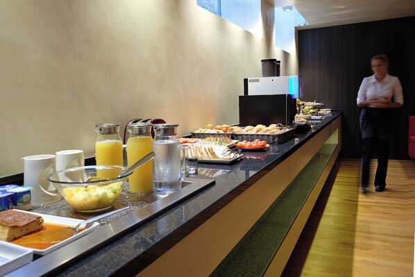 Uma mesa de buffet com diversos alimentos e bebidas.