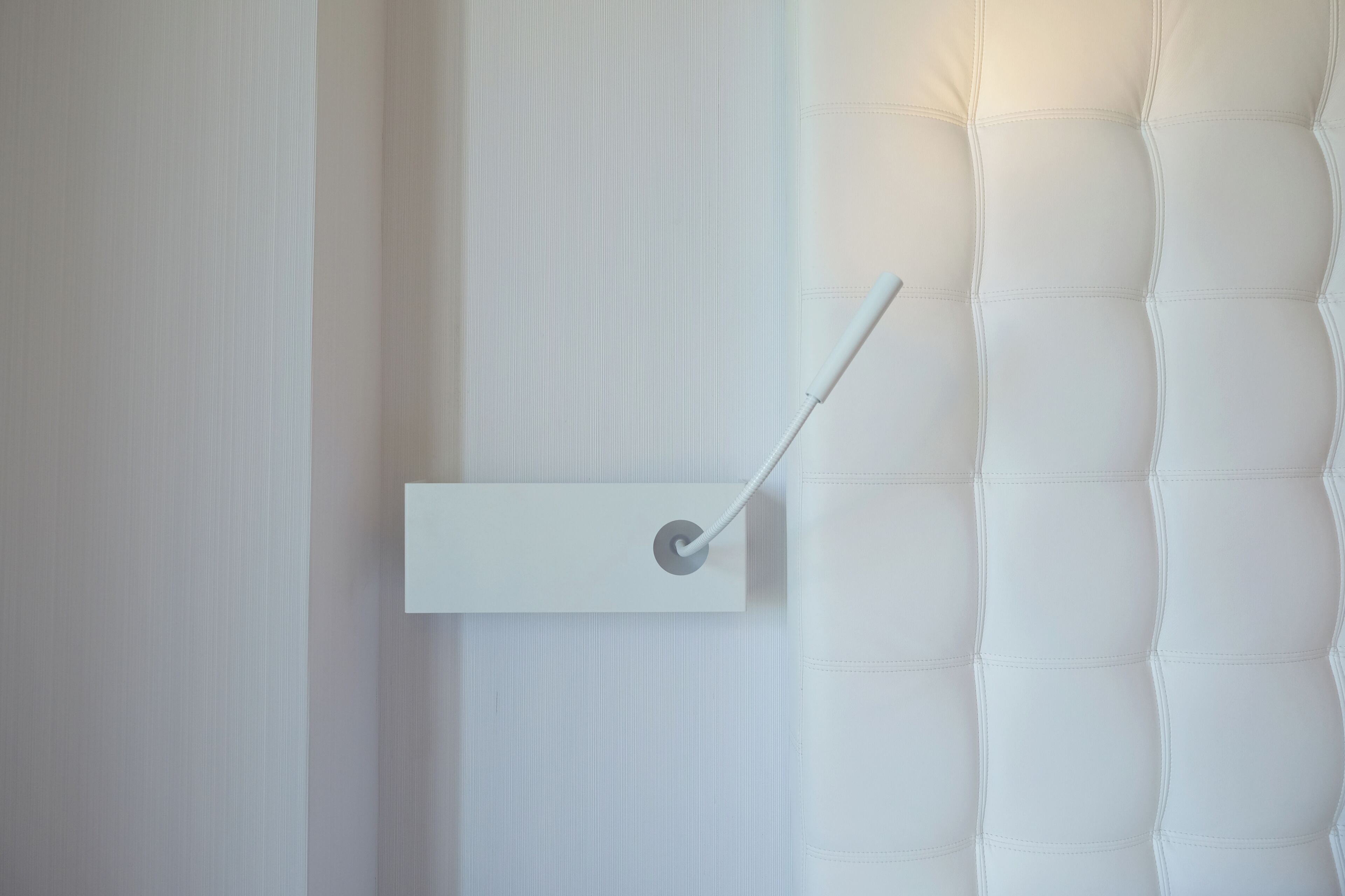 A modern, minimalist wall-mounted light fixture with a sleek design.