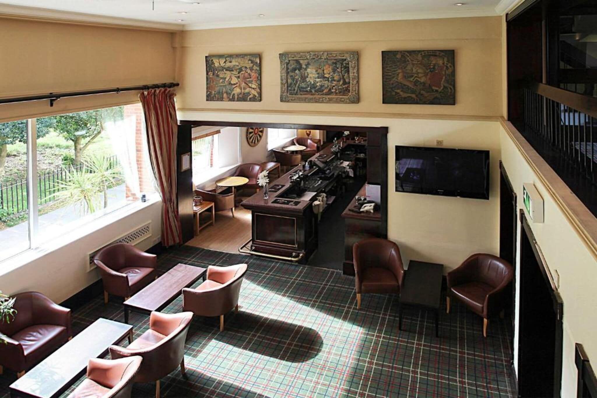 Een hotel lobby met een bar, zithoekjes en kunstwerken aan de muren.