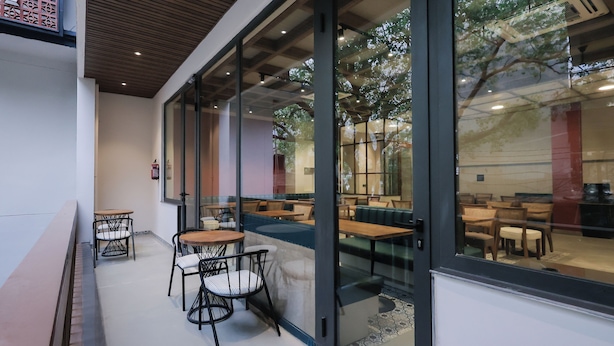Een modern zithoek met glazen wanden, een houten plafond en comfortabele zittingen.