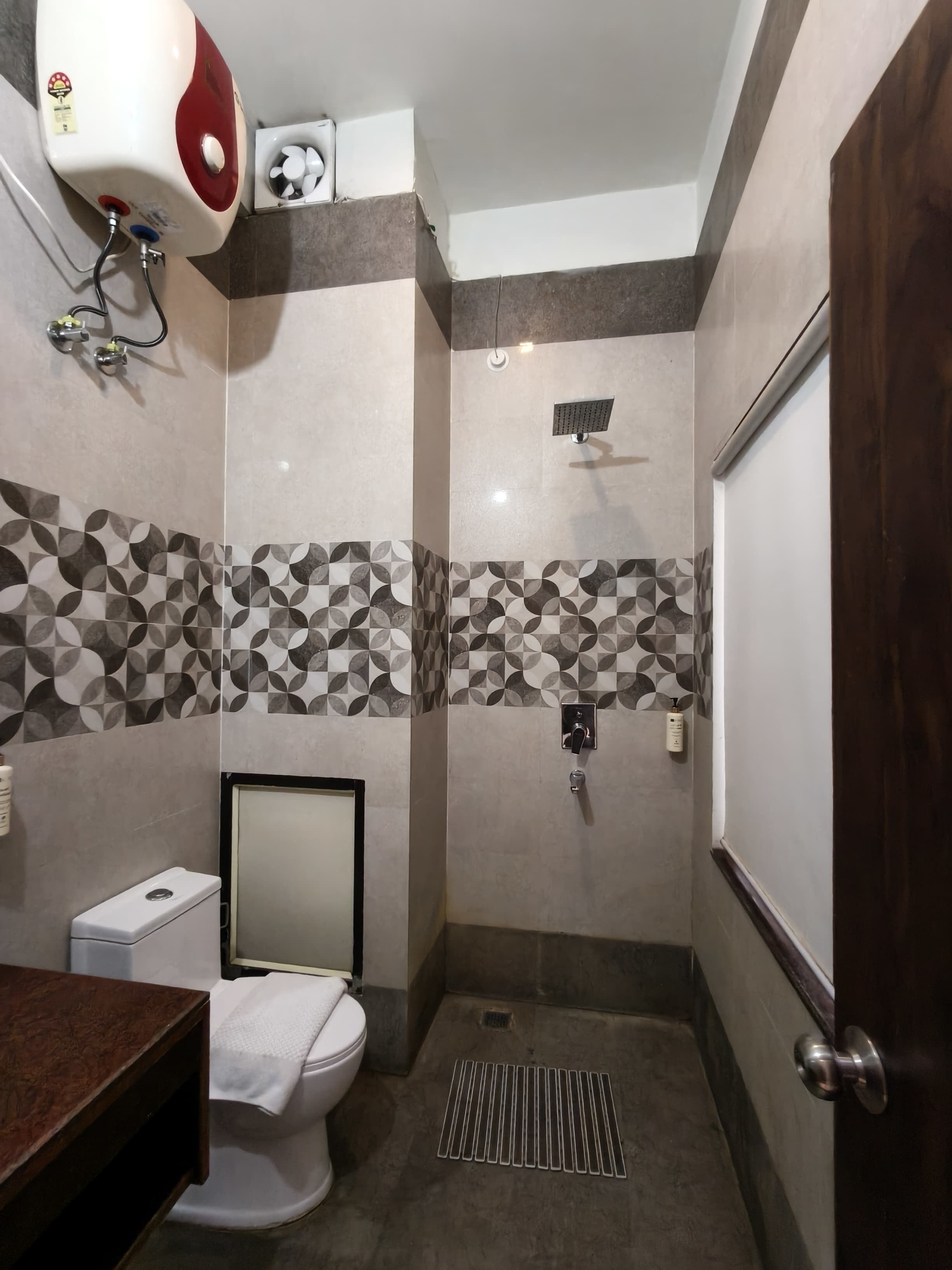 Ein Badezimmer mit Toilette, Dusche und Wandtrockner.