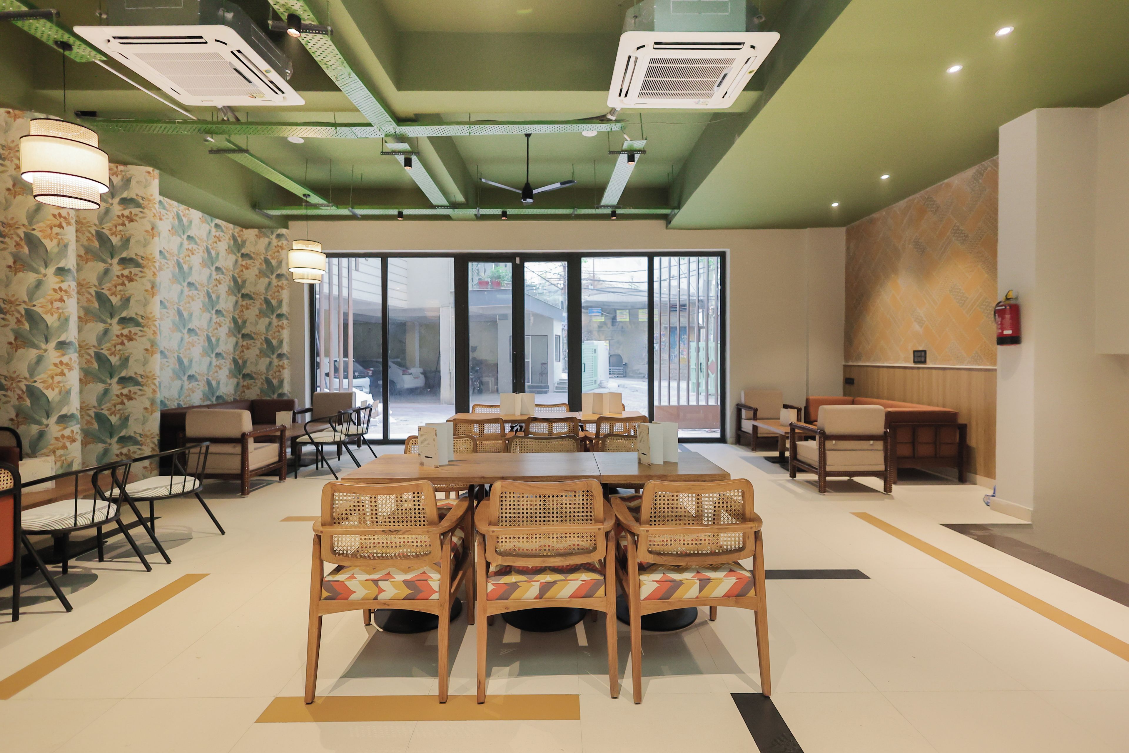 A conference room with a large table and chairs, a patterned wall, and a view through the windows.