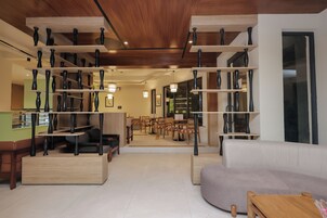 Un intérieur moderne avec un espace salon central, des étagères en bois et un coin repas.