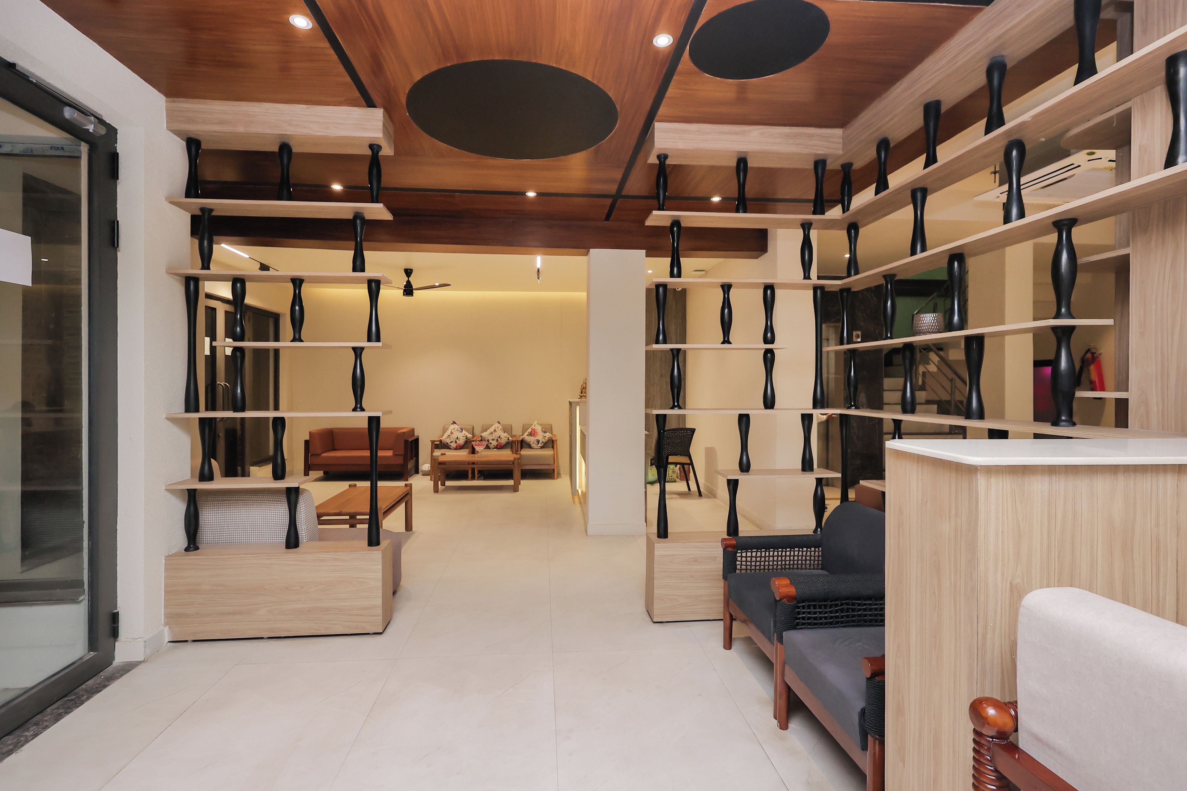 Una sala moderna con sofá, mesa de centro y estanterías con jarrones.