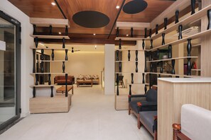 Un salon moderne avec un canapé, une table basse et des étagères ornées de vases.
