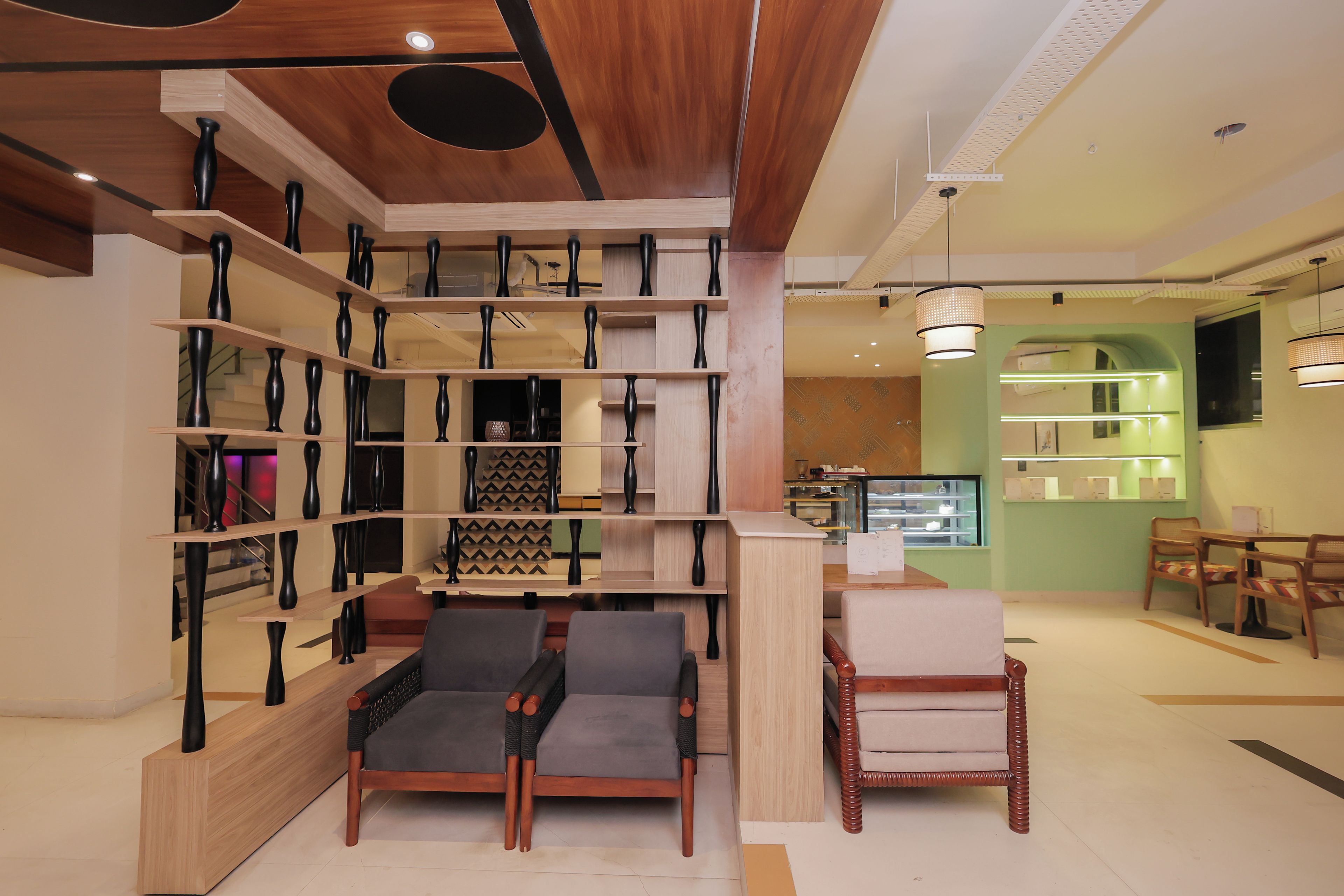A modern interior with wooden shelves, a seating area, and a counter with a menu.
