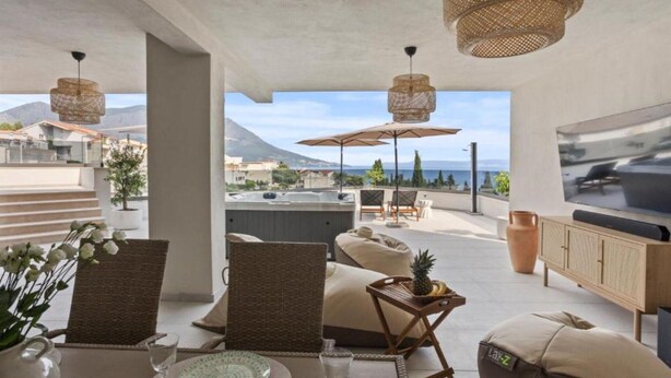 A modern outdoor seating area with wicker furniture, a hot tub, and a TV. - Three-Bedroom Penthouse Apartment (Omis)
