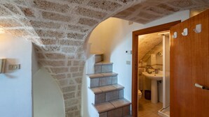 A staircase leading to a bathroom with a sink and toilet. - Palazzo Bellavista by Rentbeat (Ostuni)