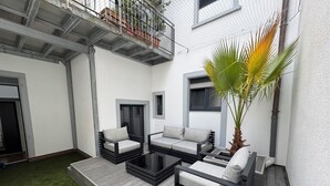 A modern outdoor seating area with a wooden deck, two sofas, and a coffee table. - HLH - Luxus Familiensuite mit Terrasse (Freiburg im Breisgau)