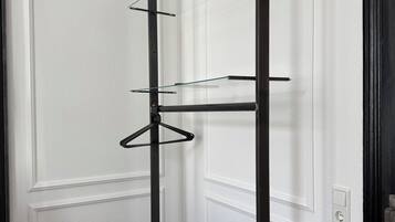 A black metal shelf unit with multiple shelves against a white door.