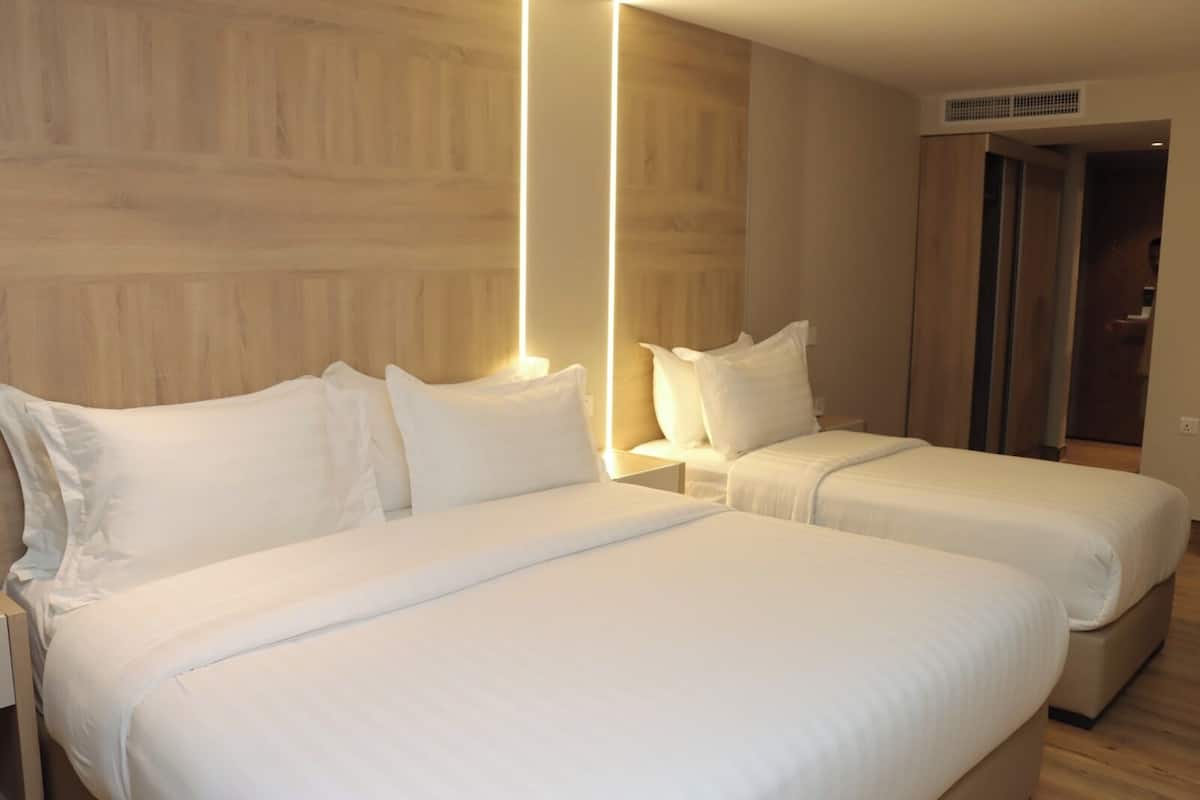 Une chambre d’hôtel avec deux lits, des murs recouverts de lambris en bois et un design moderne.