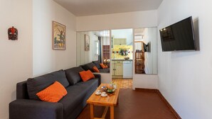 A modern living room with a sofa, a wooden coffee table, and a flat-screen TV mounted on the wall. - VUE ROSSETTI AP4465 by Riviera Holiday Homes (Niza)