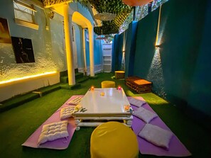 Ein Spa-Raum mit Massageliege, Handtüchern und einem kleinen Holzschemel.
