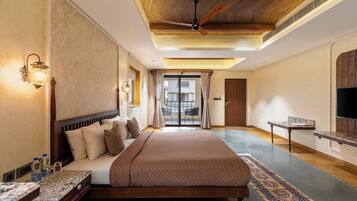 Une chambre d’hôtel spacieuse, dotée d’un grand lit, d’un plafond en bois et offrant une vue sur l’extérieur.